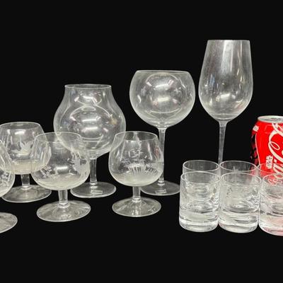 Sale Photo Thumbnail #580: Includes six etched shot glasses, a brandy snifter, five cordials, and three wine glasses. Total of 15 pieces. Some pieces are unmarked, but are believed to be Moser. Measurement of largest: 9.25”H. [CS]