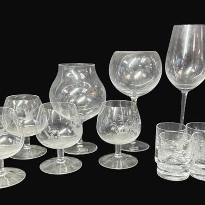 Sale Photo Thumbnail #579: Includes six etched shot glasses, a brandy snifter, five cordials, and three wine glasses. Total of 15 pieces. Some pieces are unmarked, but are believed to be Moser. Measurement of largest: 9.25”H. [CS]