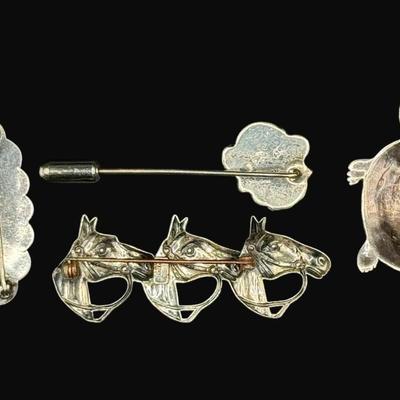 Sale Photo Thumbnail #634: **WIRE TRANSFER IS REQUIRED IF SHIPPED.** [26.57g] Includes a turquoise cabochon stick pin, a marcasite turtle, a horse head pin, and a bell pin. The horse head pin is marked “Beau Navajo.” Total of four pieces. Measurement of largest: 2.25”. Silver