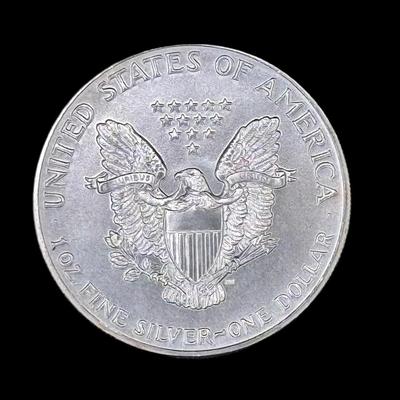 Sale Photo Thumbnail #706: **WIRE TRANSFER IS REQUIRED IF SHIPPED.** 1986 was the first year the American Eagle was produced. This collectible example is believed to be uncirculated. Silver content is 90%. **ALL PRECIOUS METALS SALES ARE FINAL. NO REFUNDS WILL BE GIVEN FOR ANY REAS