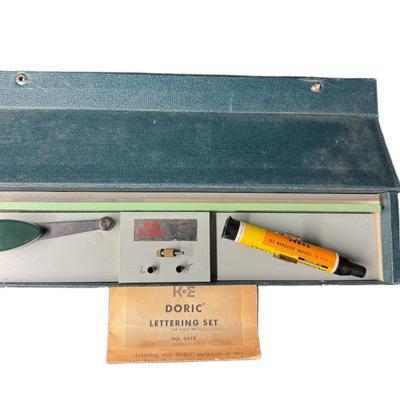 Sale Photo Thumbnail #724: Includes a Stanley London nautical brass compass, a K&E Doric lettering set, and a pair of Jason 2x opera theater glasses. Total of three pieces. Not tested. Measurement of largest: 12.5”. [CS]