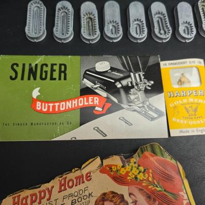 Singer button holder with large fabric scraps and vintage needles