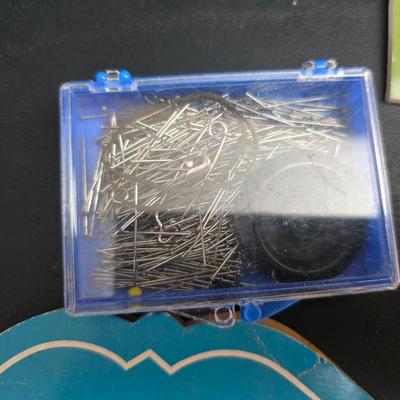 Singer button holder with large fabric scraps and vintage needles