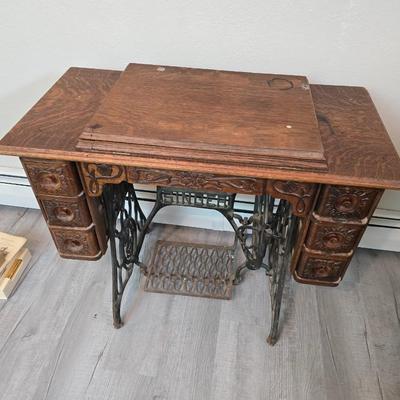 antique Singer treadle sewing machine with a wooden cabinet Complete with accessories and original manual