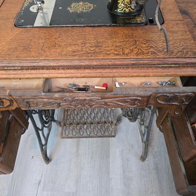 antique Singer treadle sewing machine with a wooden cabinet Complete with accessories and original manual