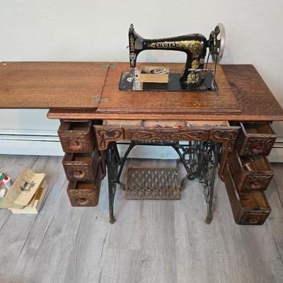 antique Singer treadle sewing machine with a wooden cabinet Complete with accessories and original manual