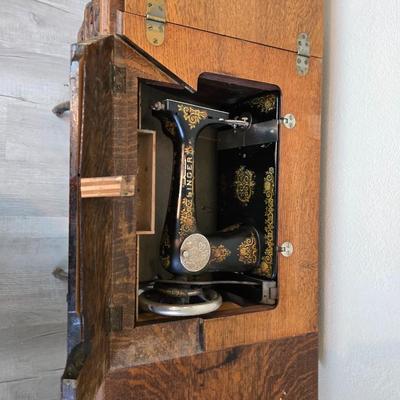 antique Singer treadle sewing machine with a wooden cabinet Complete with accessories and original manual