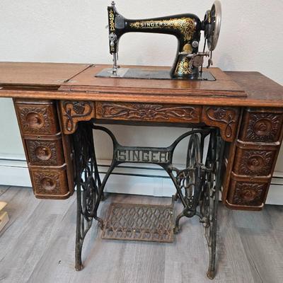 antique Singer treadle sewing machine with a wooden cabinet Complete with accessories and original manual