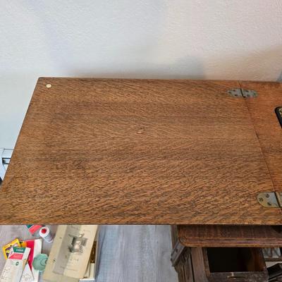 antique Singer treadle sewing machine with a wooden cabinet Complete with accessories and original manual