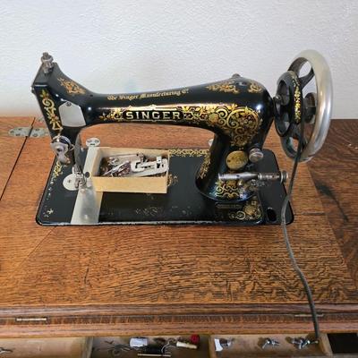 antique Singer treadle sewing machine with a wooden cabinet Complete with accessories and original manual