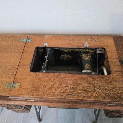 antique Singer treadle sewing machine with a wooden cabinet Complete with accessories and original manual