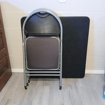 Cosco card table with black top and 4 matching folding chairs