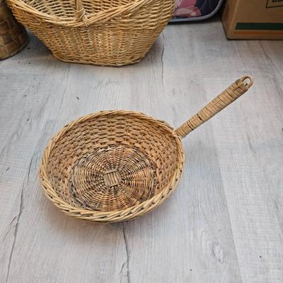 Light colored wicker baskets and a vintage macrame and beaded mirror with a frosted scene