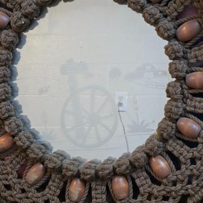 Light colored wicker baskets and a vintage macrame and beaded mirror with a frosted scene