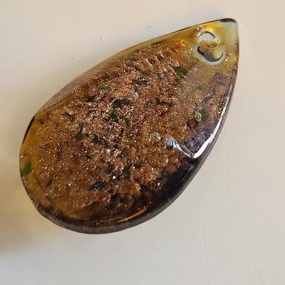 Sale Photo Thumbnail #285: This auction lot is for a Man-made Amber-Like Glass Pendant.  This handsome pendant is drilled and ready for a nice necklace to sport its beauty. See photo for size.