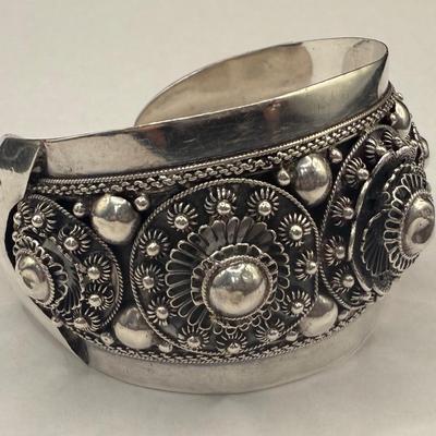 Sale Photo Thumbnail #754: Most likely Mid Century design.  Wide, non-flexible cuff.  Highly decorated with rosettes, hollow beads and floral motifs.  2.5" wide. A successful wire transfer is required if this item is to be shipped.  [RM]