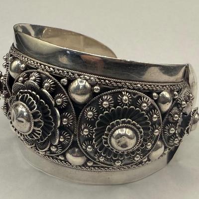 Sale Photo Thumbnail #753: Most likely Mid Century design.  Wide, non-flexible cuff.  Highly decorated with rosettes, hollow beads and floral motifs.  2.5" wide. A successful wire transfer is required if this item is to be shipped.  [RM]