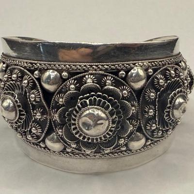Sale Photo Thumbnail #752: Most likely Mid Century design.  Wide, non-flexible cuff.  Highly decorated with rosettes, hollow beads and floral motifs.  2.5" wide. A successful wire transfer is required if this item is to be shipped.  [RM]