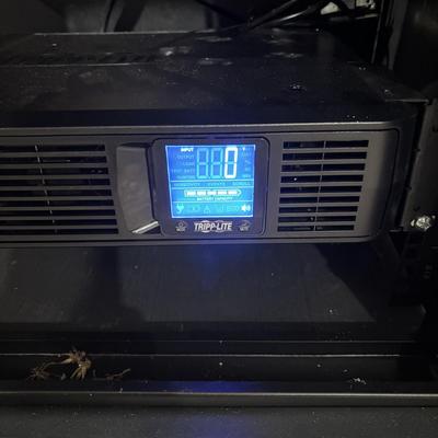 LOT 148: Pure Sign Tripp Light Uninterruptible SMART1500LCD 1500VA Rack Mount UPS Battery Backup, 900W, in cooling rack