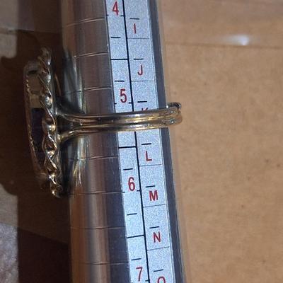 Sale Photo Thumbnail #1430: we are not sure what kind of stone this is, it looks more purple than pink- the lighting made some photos look pink.  It is sterling but the band is also adjustable so at it's smallest size it's just bigger than a 5.  We think this is Wampum shell and tha