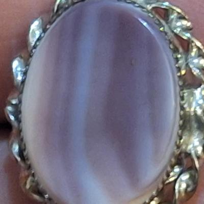 Sale Photo Thumbnail #1423: we are not sure what kind of stone this is, it looks more purple than pink- the lighting made some photos look pink.  It is sterling but the band is also adjustable so at it's smallest size it's just bigger than a 5.  We think this is Wampum shell and tha