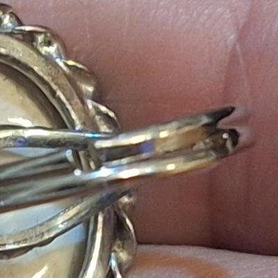 Sale Photo Thumbnail #1429: we are not sure what kind of stone this is, it looks more purple than pink- the lighting made some photos look pink.  It is sterling but the band is also adjustable so at it's smallest size it's just bigger than a 5.  We think this is Wampum shell and tha