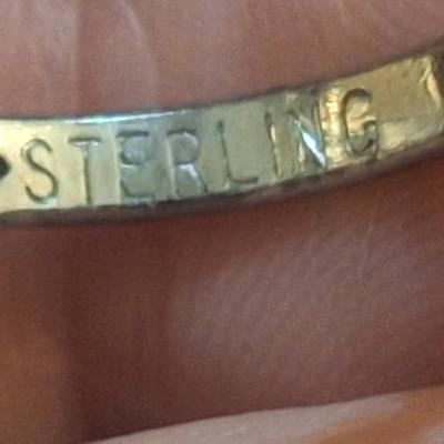 Sale Photo Thumbnail #1428: we are not sure what kind of stone this is, it looks more purple than pink- the lighting made some photos look pink.  It is sterling but the band is also adjustable so at it's smallest size it's just bigger than a 5.  We think this is Wampum shell and tha