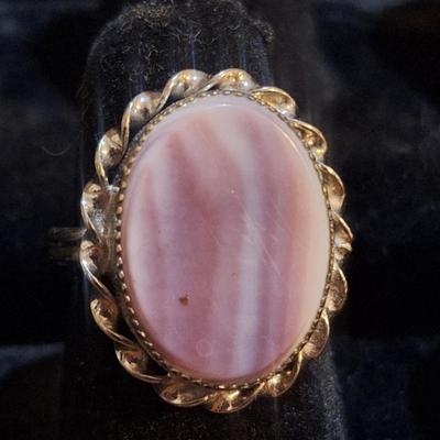 Sale Photo Thumbnail #1425: we are not sure what kind of stone this is, it looks more purple than pink- the lighting made some photos look pink.  It is sterling but the band is also adjustable so at it's smallest size it's just bigger than a 5.  We think this is Wampum shell and tha
