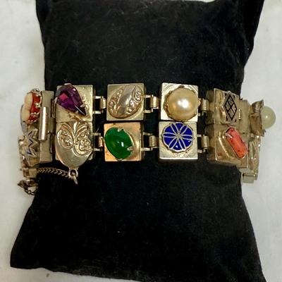 Sale Photo Thumbnail #83: Vintage Victorian Revival bracelet. This beautiful bracelet has two rows of square light gold tone (almost silver tone) base links. There are prong set glass rhinestones in colors of purple, light blue, green, orange, faux opal, light blue and faux pearl.