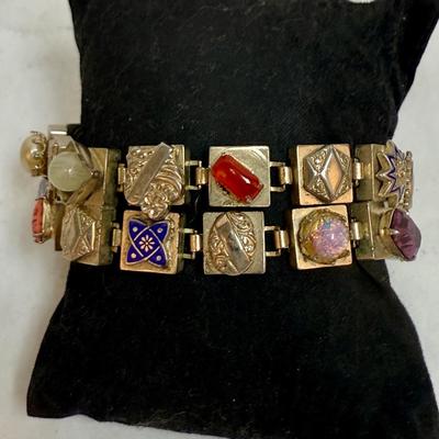 Sale Photo Thumbnail #81: Vintage Victorian Revival bracelet. This beautiful bracelet has two rows of square light gold tone (almost silver tone) base links. There are prong set glass rhinestones in colors of purple, light blue, green, orange, faux opal, light blue and faux pearl.