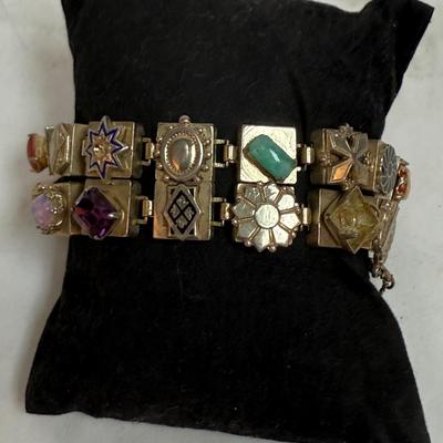 Sale Photo Thumbnail #80: Vintage Victorian Revival bracelet. This beautiful bracelet has two rows of square light gold tone (almost silver tone) base links. There are prong set glass rhinestones in colors of purple, light blue, green, orange, faux opal, light blue and faux pearl.