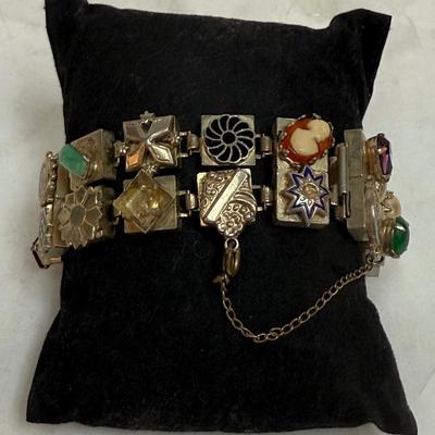 Sale Photo Thumbnail #84: Vintage Victorian Revival bracelet. This beautiful bracelet has two rows of square light gold tone (almost silver tone) base links. There are prong set glass rhinestones in colors of purple, light blue, green, orange, faux opal, light blue and faux pearl.