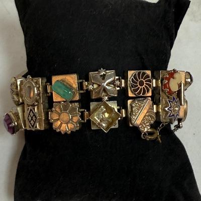 Sale Photo Thumbnail #79: Vintage Victorian Revival bracelet. This beautiful bracelet has two rows of square light gold tone (almost silver tone) base links. There are prong set glass rhinestones in colors of purple, light blue, green, orange, faux opal, light blue and faux pearl.