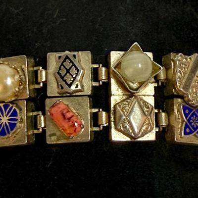 Sale Photo Thumbnail #82: Vintage Victorian Revival bracelet. This beautiful bracelet has two rows of square light gold tone (almost silver tone) base links. There are prong set glass rhinestones in colors of purple, light blue, green, orange, faux opal, light blue and faux pearl.