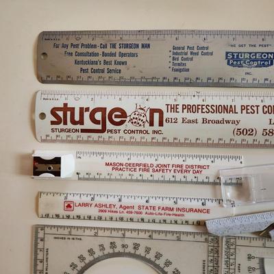 Sale Photo Thumbnail #343: This auction lot is for a Realm of Rulers.  These eight rulers can be both useful and collectible. The vintage Sturgeon rulers are metal, one ruler has a pencil sharpener, another has a magnifier and one is a letter opener.  A couple of protractors, too.