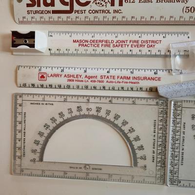 Sale Photo Thumbnail #342: This auction lot is for a Realm of Rulers.  These eight rulers can be both useful and collectible. The vintage Sturgeon rulers are metal, one ruler has a pencil sharpener, another has a magnifier and one is a letter opener.  A couple of protractors, too.