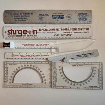 Sale Photo Thumbnail #340: This auction lot is for a Realm of Rulers.  These eight rulers can be both useful and collectible. The vintage Sturgeon rulers are metal, one ruler has a pencil sharpener, another has a magnifier and one is a letter opener.  A couple of protractors, too.