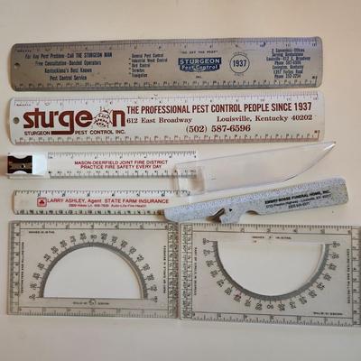 Sale Photo Thumbnail #345: This auction lot is for a Realm of Rulers.  These eight rulers can be both useful and collectible. The vintage Sturgeon rulers are metal, one ruler has a pencil sharpener, another has a magnifier and one is a letter opener.  A couple of protractors, too.