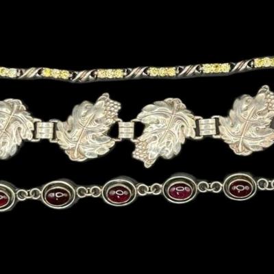 Sale Photo Thumbnail #835: **WIRE TRANSFER IS REQUIRED IF SHIPPED.** [52.15g] Includes a garnet cabochon bracelet, a prong set citrine bracelet, and a Danish style leaf motif bracelet. Total of three pieces. Measurement of longest: 8”. Silver content confirmed using Niton XRF pre