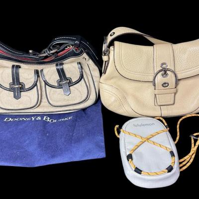 Sale Photo Thumbnail #879: Includes a Lulu Lemon crossbody wallet, a Coach bag, and a Dooney & Bourke bag. Total of three pieces. Age related wear. Measurement of largest: 13”. [CS]