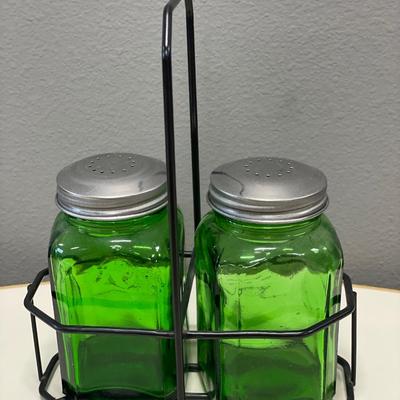 Green glass shakers in holder
