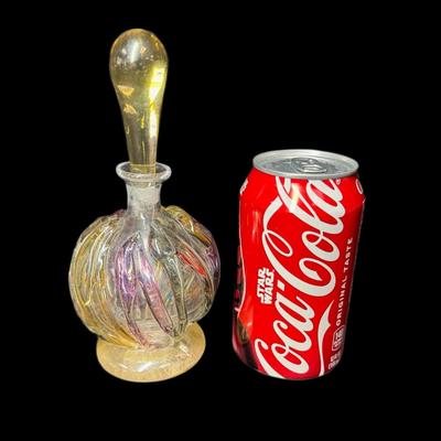Sale Photo Thumbnail #892: This vintage piece is crafted from hand blown glass. It is signed on the base. The stopper is in original condition, and is unbroken. Measurement: 7”H. Pre-auction estimate: $100-$150. [CS]