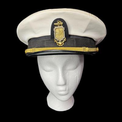Sale Photo Thumbnail #911: This Naval white peak cap belonged to a master swimmer. The size is unmarked/unknown. Age related wear. Measurement: 11.75” Diameter. [CS]