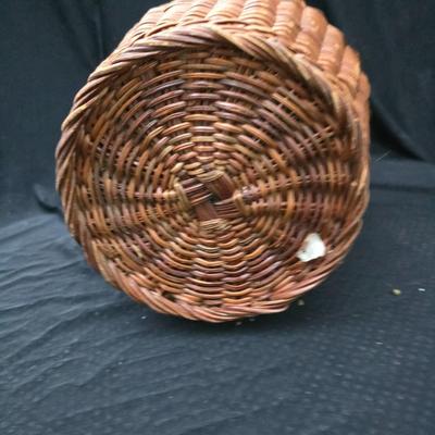 A hammered brass vase with two wicker basket vases