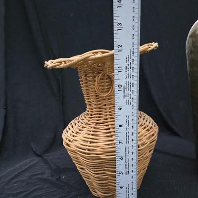 A hammered brass vase with two wicker basket vases