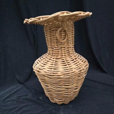 A hammered brass vase with two wicker basket vases