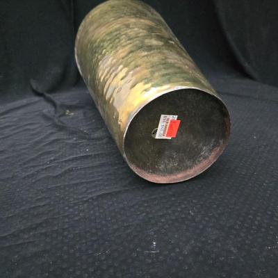 A hammered brass vase with two wicker basket vases