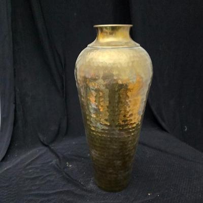 A hammered brass vase with two wicker basket vases