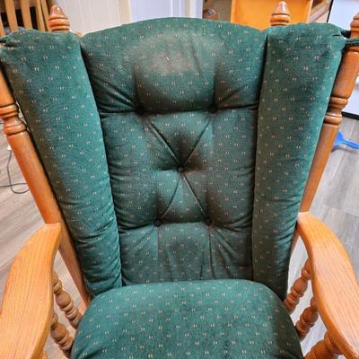 Wooden cane back glider with green cushions - a small table and an antique wooden stool