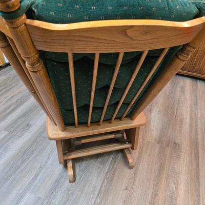 Wooden cane back glider with green cushions - a small table and an antique wooden stool